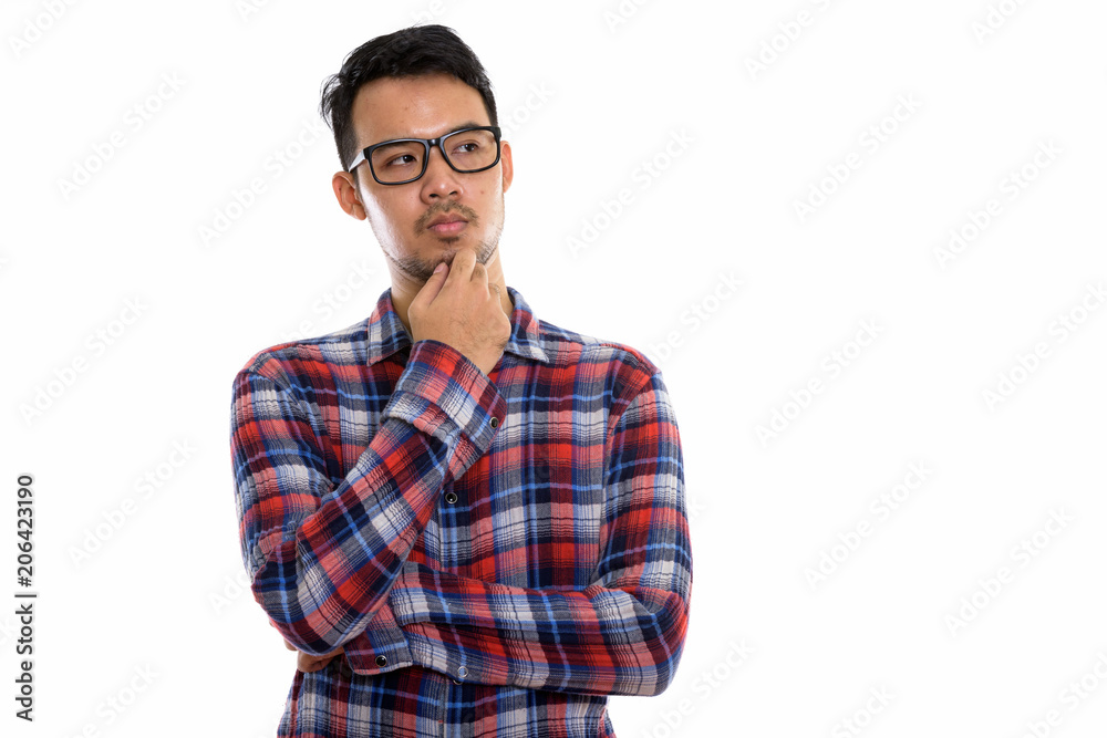 Studio shot of young Asian man thinking while wearing eyeglasses Studio shot of young Asian man thinking while wearing eyeglasses