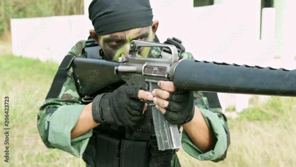 Slow motion of soldier aiming his assault rifle in urban training ...