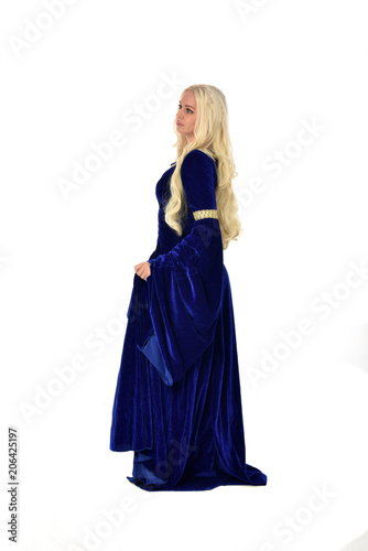 full length portrait of pretty blonde lady wearing  a blue fantasy medieval gown. standing pose on white background.