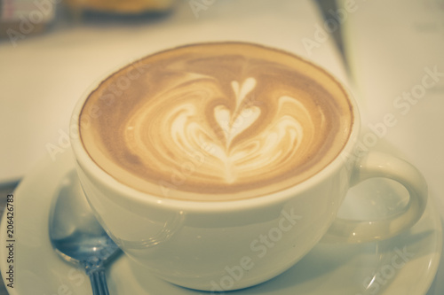 Latte art coffee on the wood table.