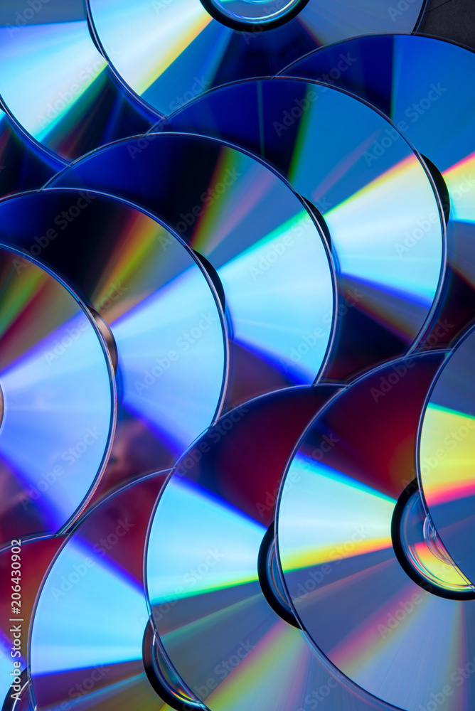 Many musical compact discs with a rainbow spectrum of colors as a bright background