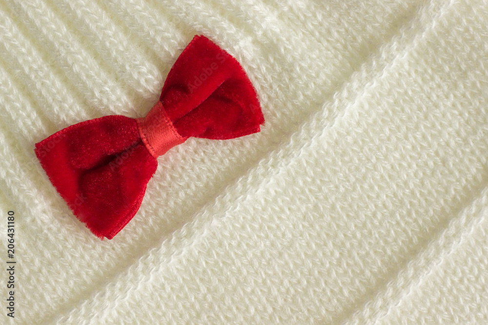 White knitted fabric with a red bow White knitted fabric with a red bow