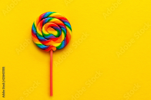 multicolored lollipop on yellow background, top view. flat lay, copy space