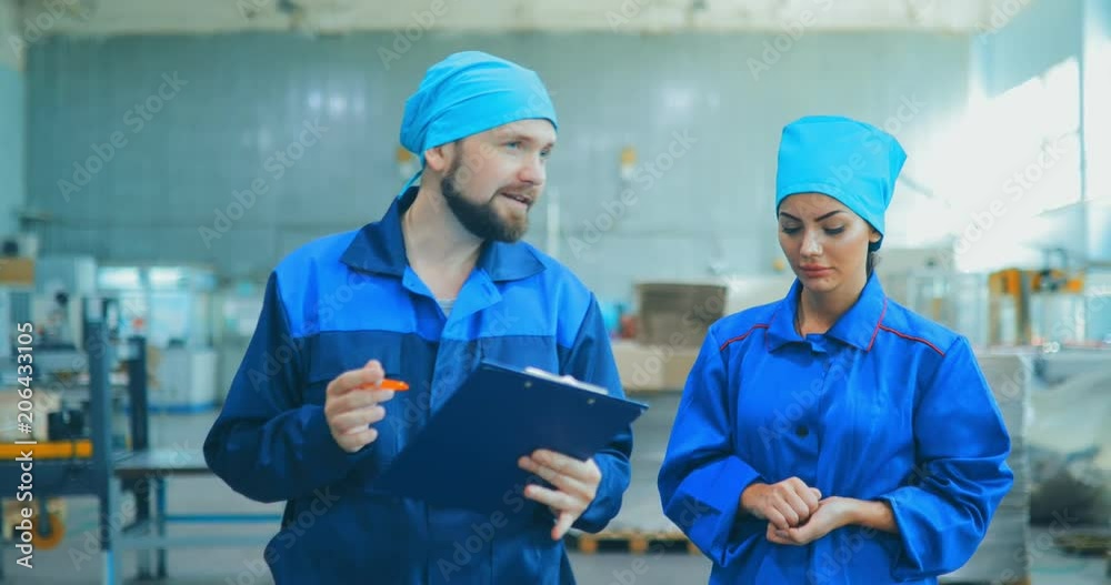 Factory inspection. People go in uniforms for an industrial enterprise and that they are discussing Factory inspection. People go in uniforms for an industrial enterprise and that they are discussing