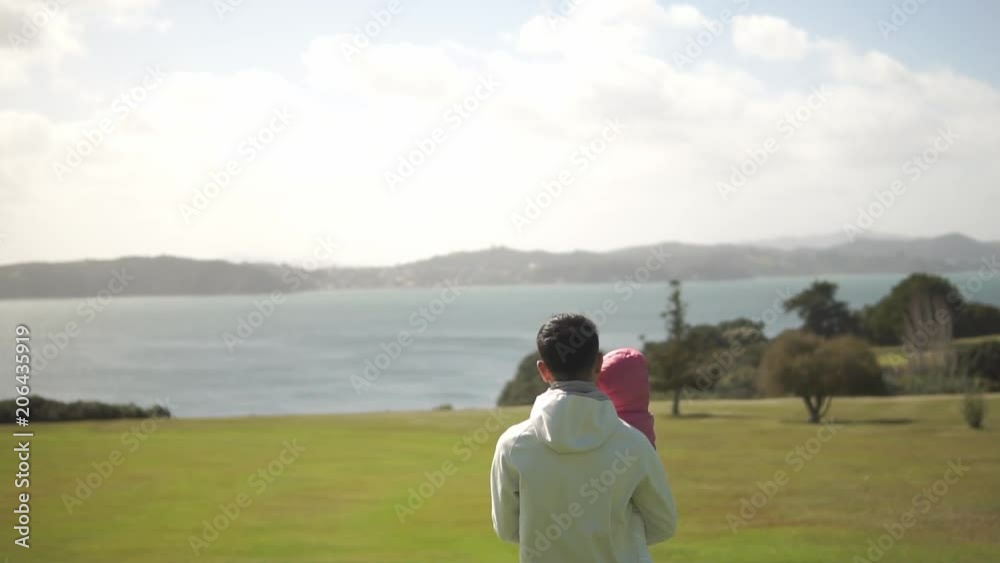 Asian chinese father with his daughter taking baby steps on a hike outdoors Asian chinese father with his daughter taking baby steps on a hike outdoors