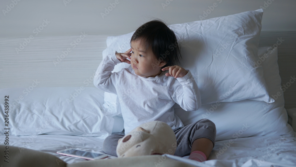 Small Asian chinese toddler sitting on the bed Small Asian chinese toddler sitting on the bed