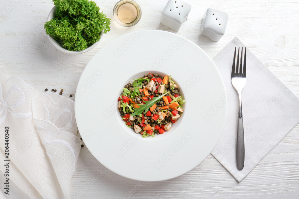Plate with delicious lentils salad on wooden table Plate with delicious lentils salad on wooden table
