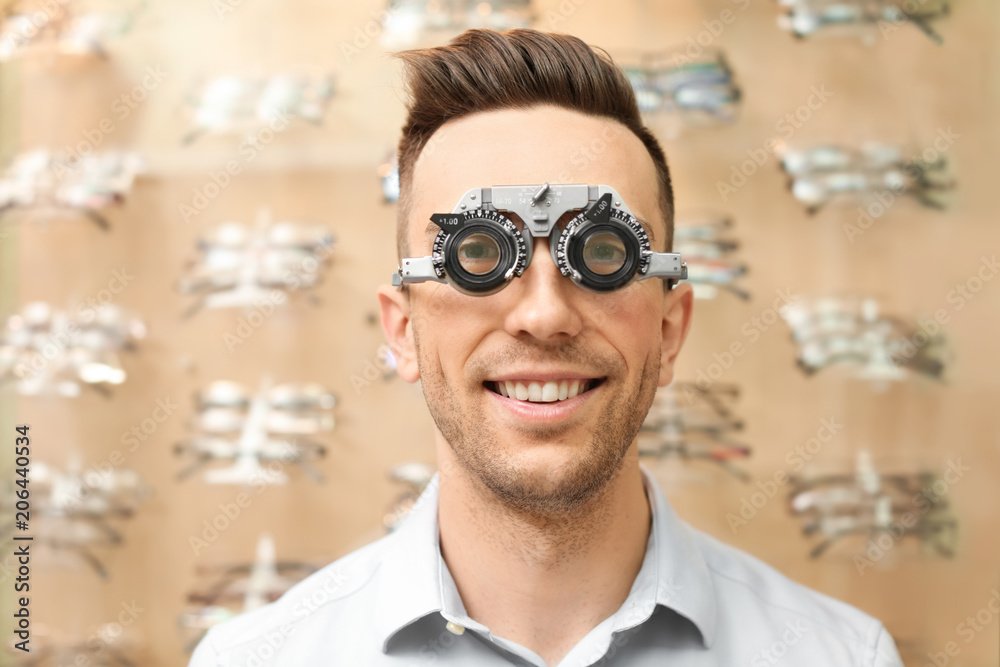 Young man having eye examination with phoropter in optical store. Ophthalmologist prescription Young man having eye examination with phoropter in optical store. Ophthalmologist prescription