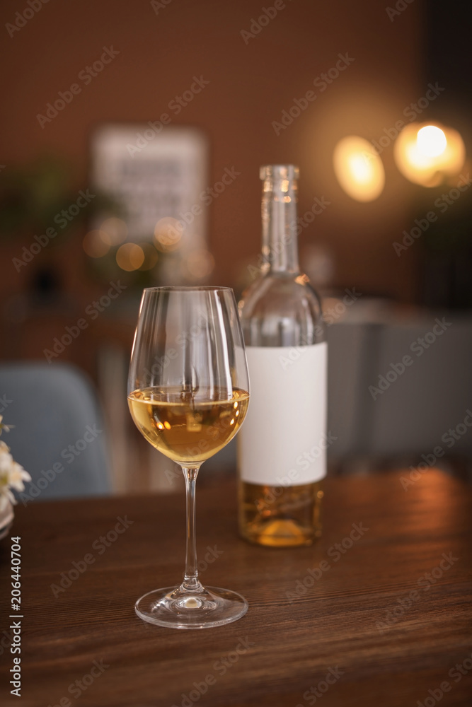 Glass and bottle of wine on table in restaurant Glass and bottle of wine on table in restaurant