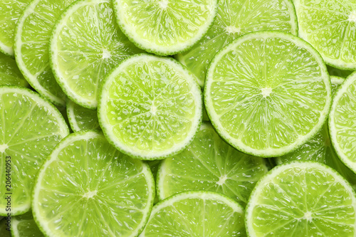 Fresh sliced ripe limes as background, top view