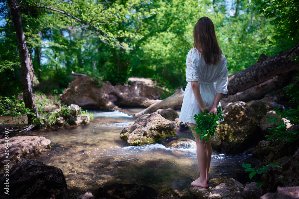 Young womqn in a white dress walking in a forest Young womqn in a white dress walking in a forest