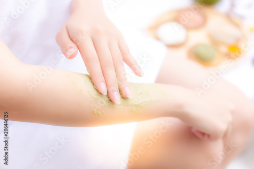 Charming beautiful woman use herbal scrubs for scrubbing her old skin cells at her beautiful arm that makes better nice skin and skin rejuvenation. Gorgeous girl scrub skin by herself at home