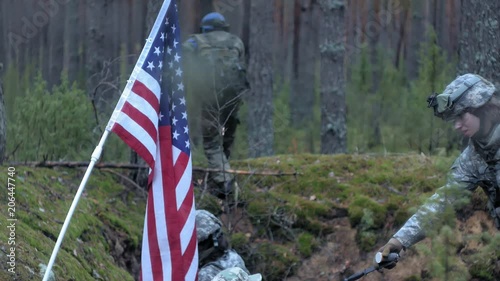 Soldiers in camouflage with combat weapons and in the US in the forest, military concept photo