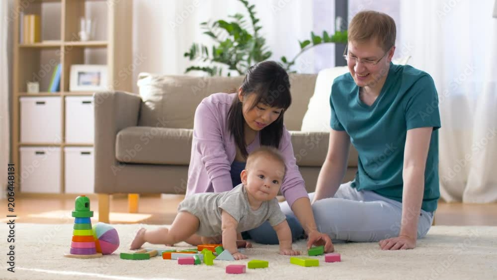 family, parenthood and people concept - happy mother, father and baby boy playing toy blocks at home family, parenthood and people concept - happy mother, father and baby boy playing toy blocks at home