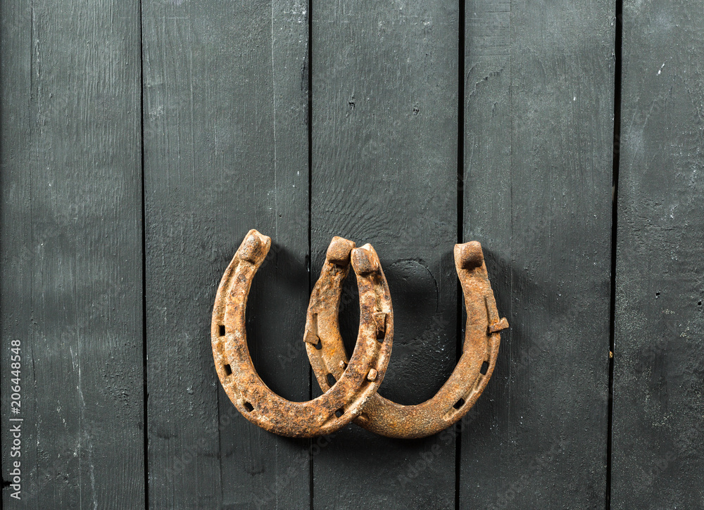 old rusty horseshoes on wooden board old rusty horseshoes on wooden board