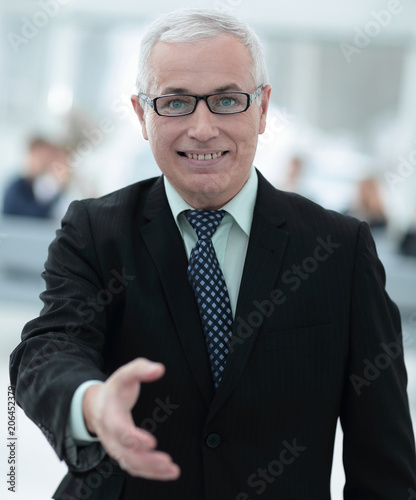 closeup of a senior businessman offering his hand for greeting.