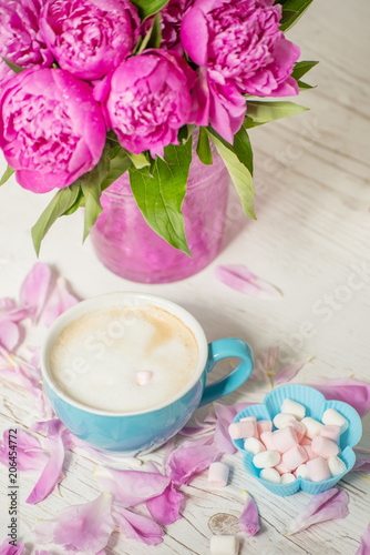 Coffee with milk and flowers pink peonies. The atmosphere of relaxation.
