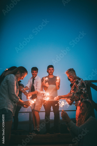 mixed group of boys and girls having fun in a summer night outside