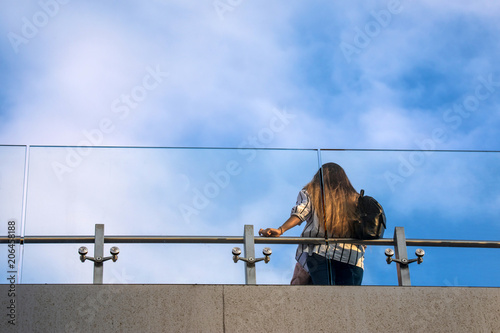 The view on the observation deck with the obstacle of steel and glass and the girl upwards