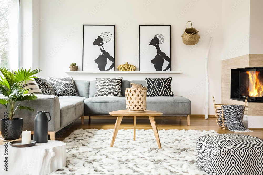 © Photographee.eu - Patterned pouf next to wooden table in african living room interior with posters. Real photo © Photographee.eu - Patterned pouf next to wooden table in african living room interior with posters. Real photo