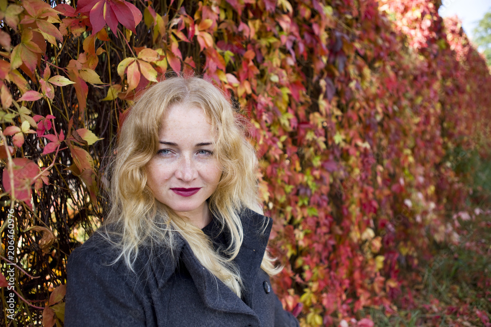Blond woman with intent look near leaves Blond woman with intent look near leaves