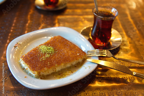 Turkish dessert kunefe with pistachio powder and tea