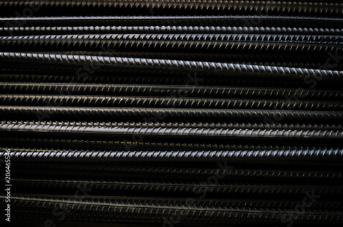 Close up of iron armature rod steel rolled stacked pile background. industrial texture construction concept. Copy space. Stack of heavy metal grey color reinforcing bundle bars, technology pattern