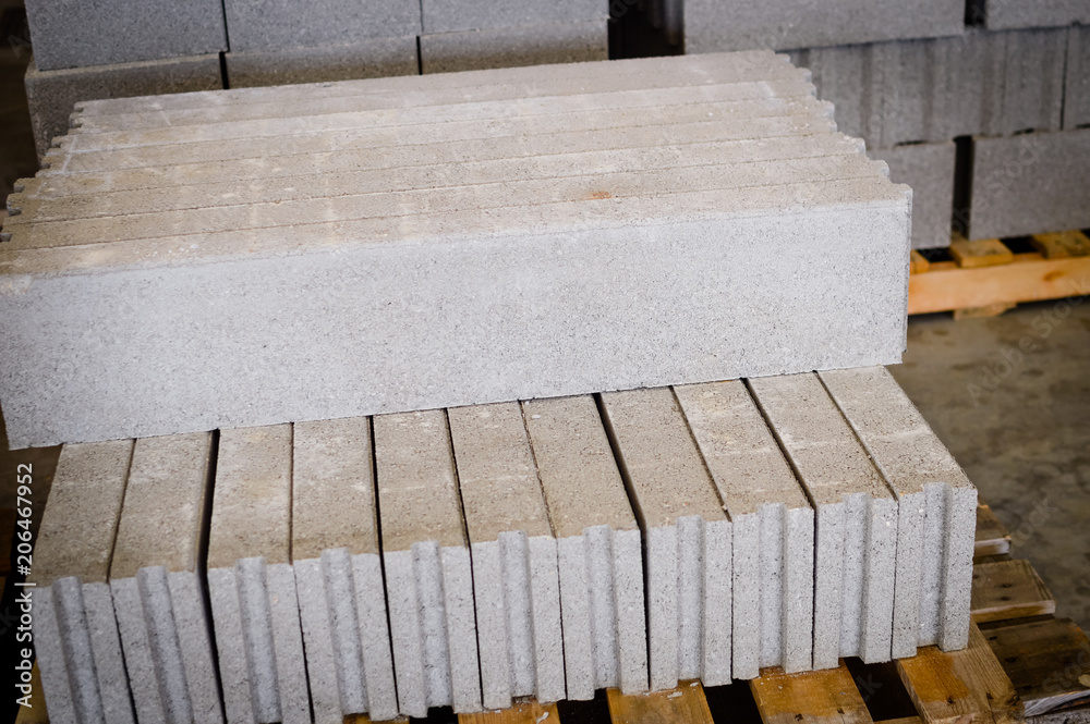 Motion blur image of cement building blocks stacked piled in warehouse background, closeup fabric plant manufacture grey textured abstract surface Motion blur image of cement building blocks stacked piled in warehouse background, closeup fabric plant manufacture grey textured abstract surface