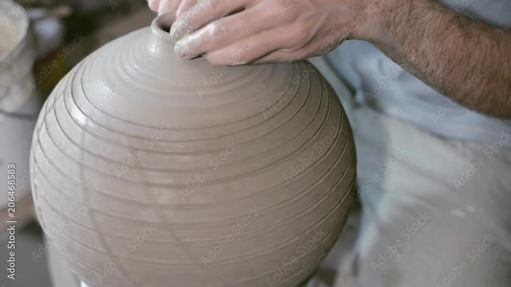 Closeup potter rotate jar with crack texture on potter's wheel and make neck Closeup potter rotate jar with crack texture on potter's wheel and make neck