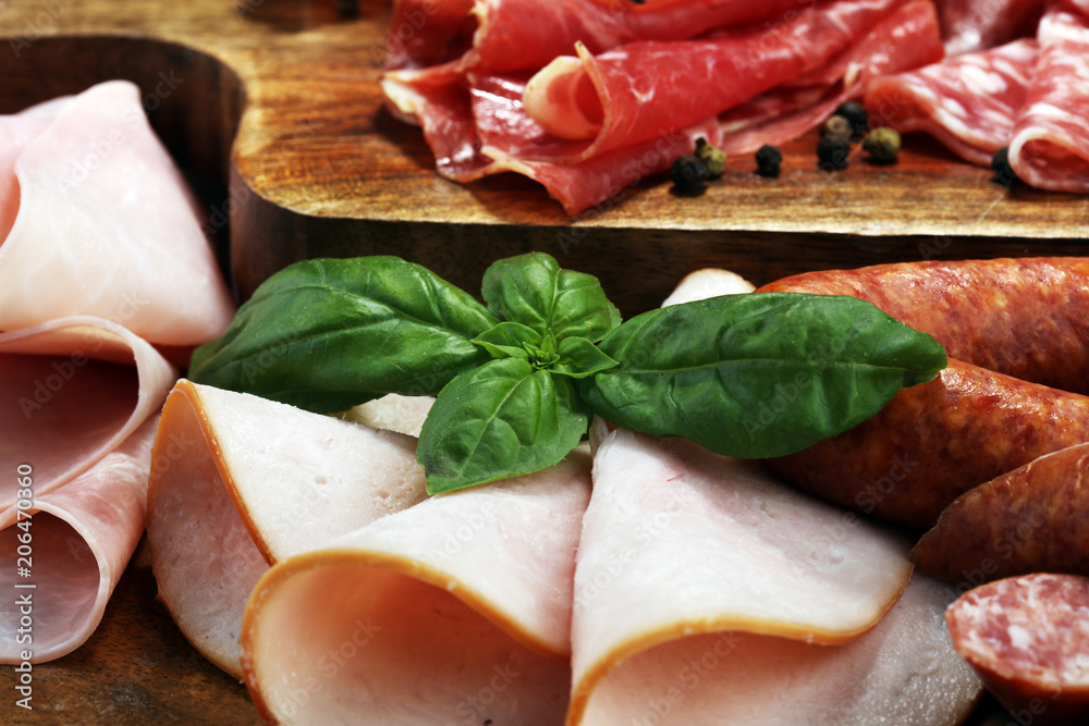 Food tray with delicious salami, ham, fresh sausages and herbs. Meat platter with selection Food tray with delicious salami, ham, fresh sausages and herbs. Meat platter with selection