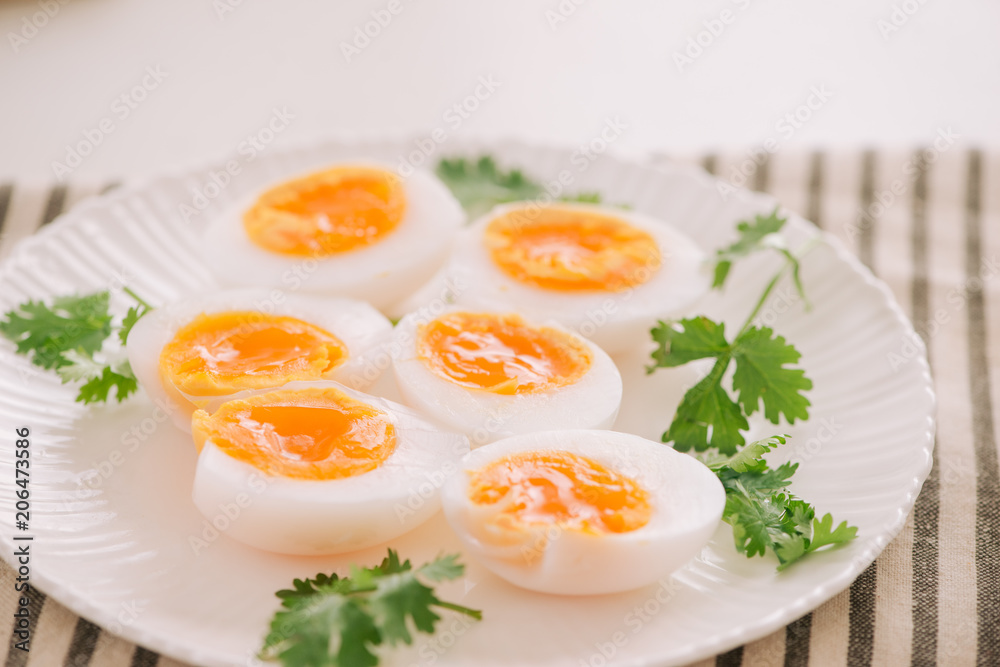 Close up medium soft boiled duck egg portion on white dish Close up medium soft boiled duck egg portion on white dish