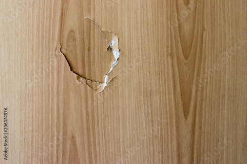 A broken wooden door and a hole in the door close up