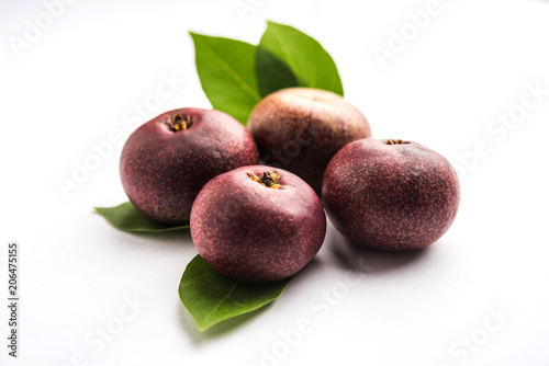 Fresh Kokum or Garcinia indica fruit from India isolated over white or in cane basket with leaves. selective focus photo