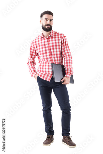 Satisfied smiling young businessman carrying laptop under the arm looking at camera. Full body isolated on white background. 