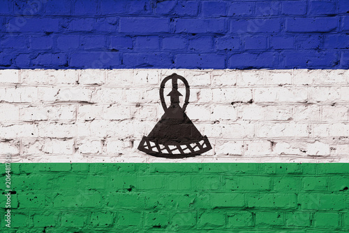 Texture of a flag of lesotho on a pink brick wall.