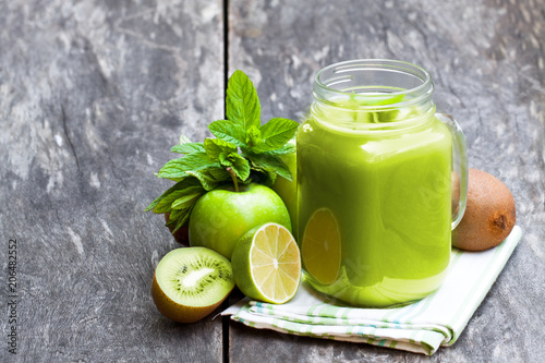 Fresh  smoothie with green fruits in a glass jar mug on wooden table