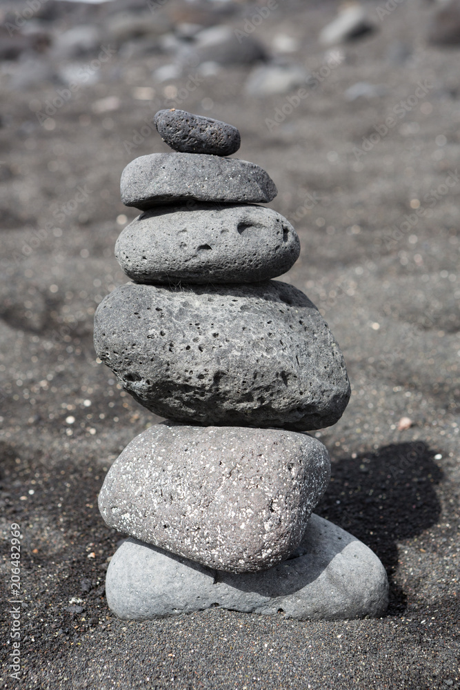 Balanced stacked stones or pebbles on a black sand beach. Balanced stacked stones or pebbles on a black sand beach.