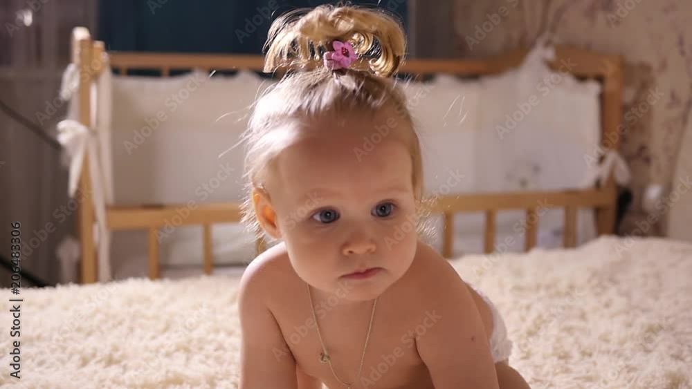 Child baby girl toddler stands up on legs and walk on a bed in slow motion Child baby girl toddler stands up on legs and walk on a bed in slow motion