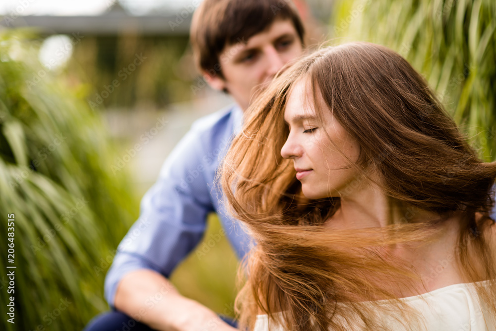 Woman swaying hair, man sitting in background. Woman swaying hair, man sitting in background.