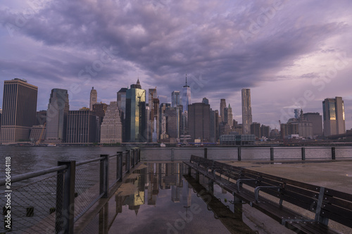 New York City skyline reflection in water puddle at Brooklyn Bridge Park on moody morning  © TetyanaOhare