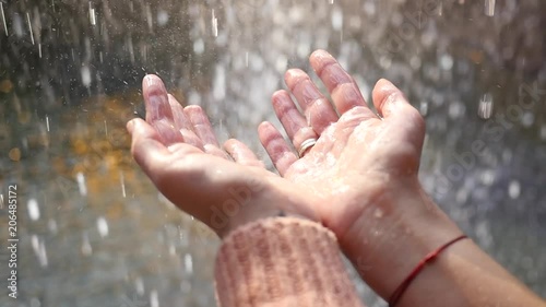 Human palms catching raindrops - abundance of water on the planet - long awaited rain