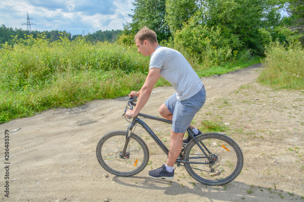 the athlete goes on a bike ride on a cross-country road.Walking on bike.Healthy lifestyle