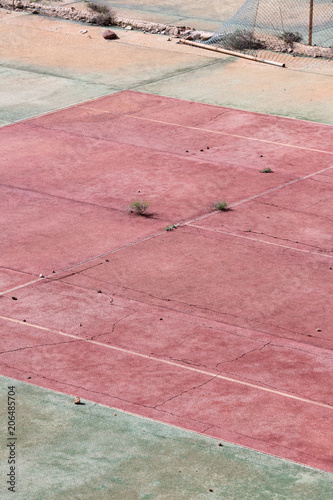 An empty and abandoned hardcourt tennis court. © michiel