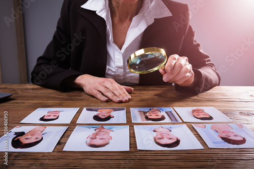 Businessperson Looking At Candidate's Photograph