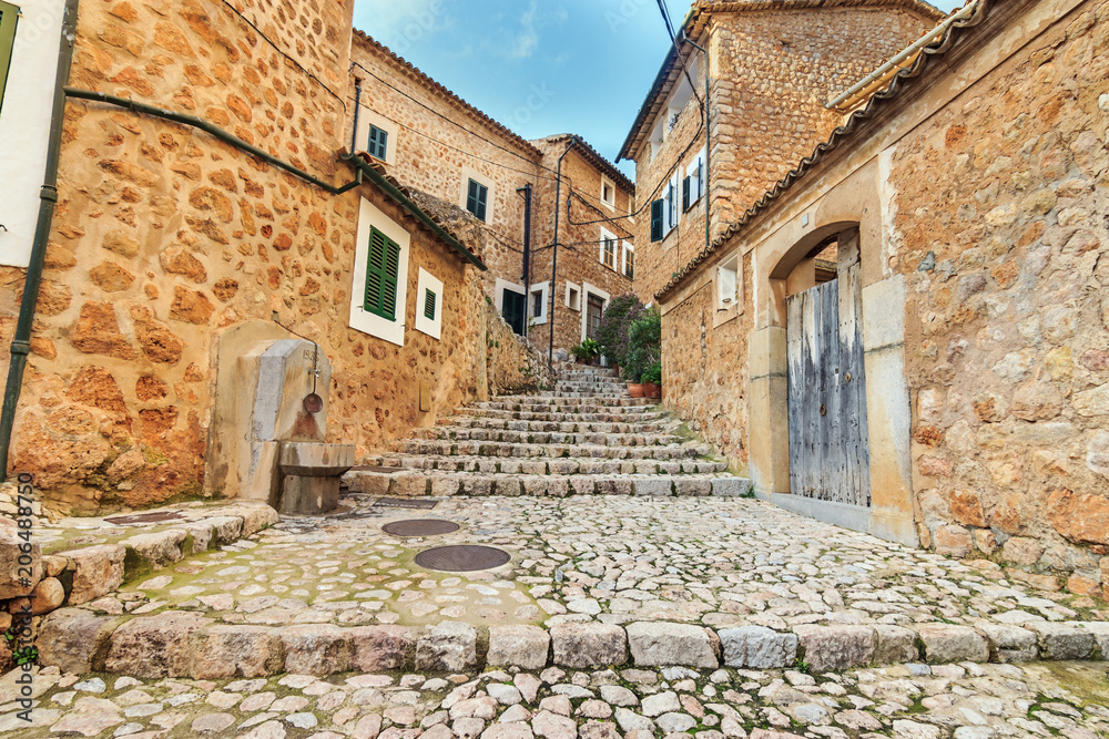 Fornalutx village cobbled street stairs and stone houses, mediterranean typical architecture in Balearic Islands
