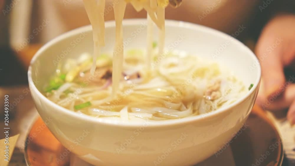 Woman eating Vietnamese classic noodle soup. Woman eating Vietnamese classic noodle soup.