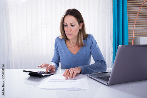 Woman Calculating Invoice With Calculator