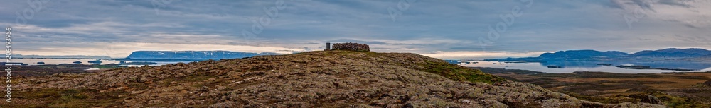 Hilltop with a stonebuilding in iceland overlooking a fjord - panorama