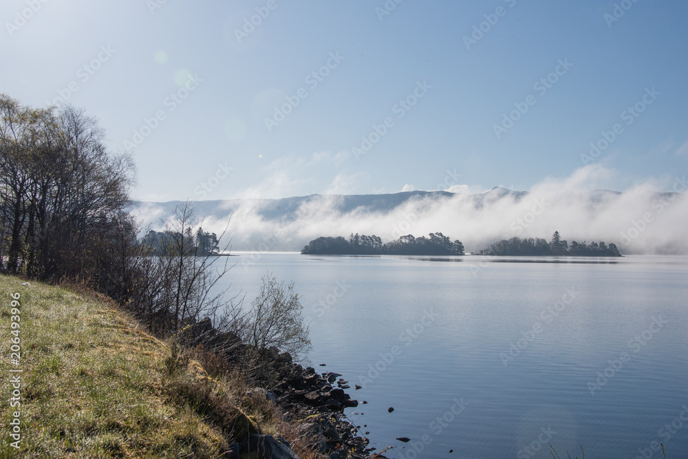 Wisps of early morning mist roll down over the loch