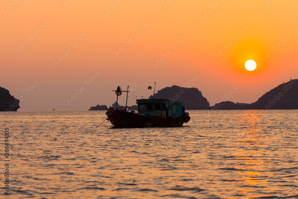 Ha Long Bay sunset with beautiful landscape and fishing ships at the harbour of Cat Ba island in north Vietnam